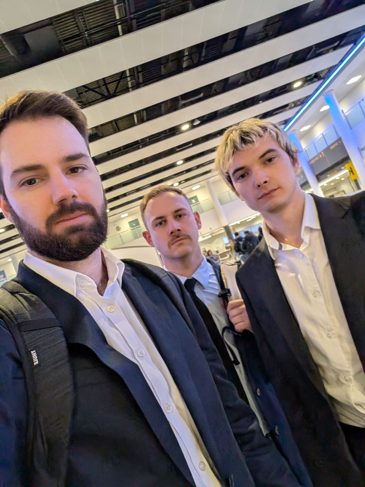 Three executives in suits at an airport terminal