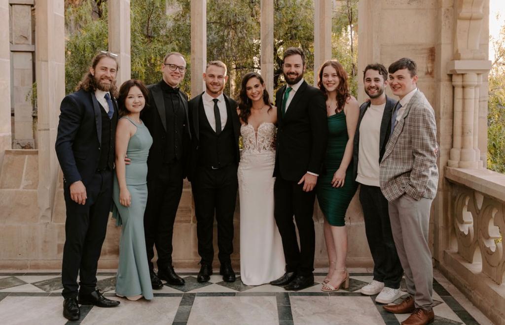 Members of the PBI executive network standing with the couple on a stone terrace