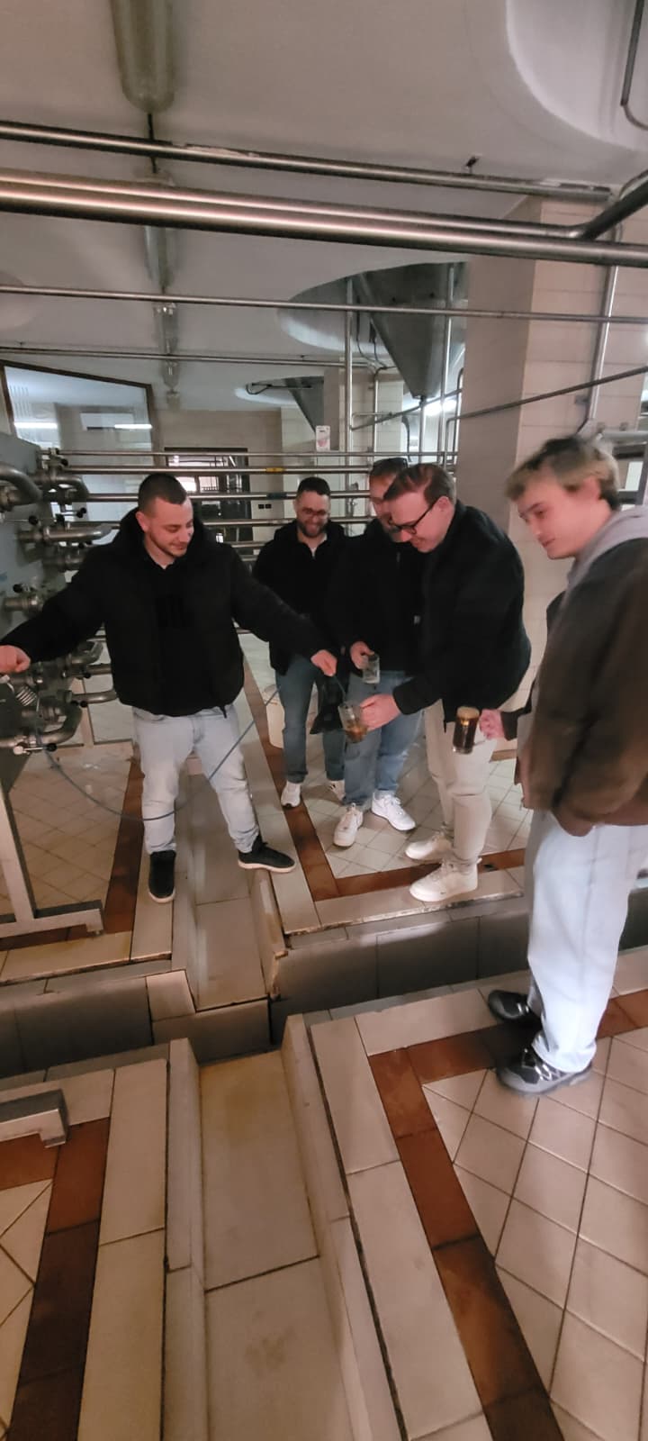 Members of the group pouring beer inside the Korçë brewery